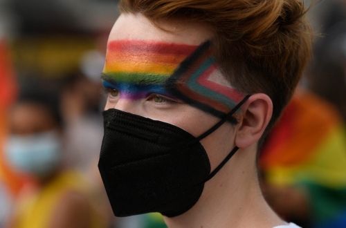 A protester with the face painted in the LGBTQ flag colours attends a demonstration to protest against LGBTQ-phobia at the Puerta del Sol square in Madrid on July 11, 2021. The killing of Samuel Luiz on July 3, 2021 in Corunna, in a suspected homophobic attack, has sparked nationwide protests to demand better protection for gay people. (Photo by OSCAR DEL POZO / AFP)